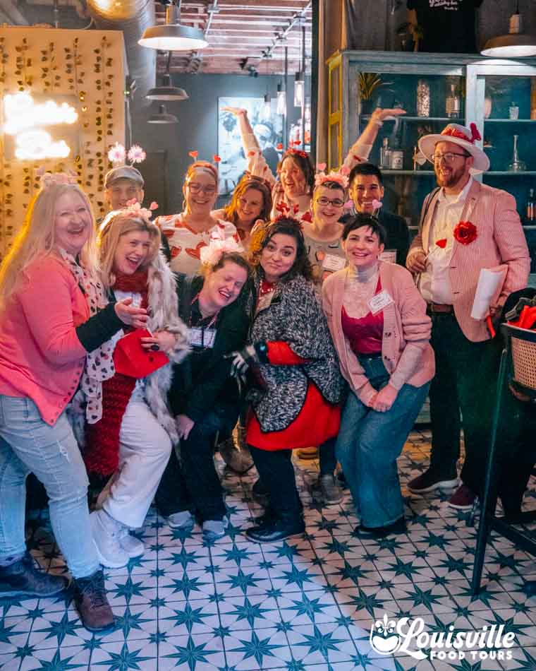 Group in Valentines Day themed clothing on a Murder Mystery Food Tour in Louisville Kentucky with Louisville Food Tours