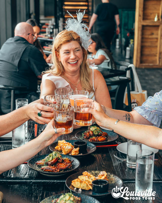 Bride and her bachelorette party doing a cheers at a restaurant